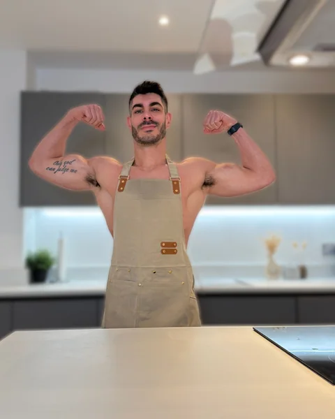 Atai in his kitchen, wearing an apron